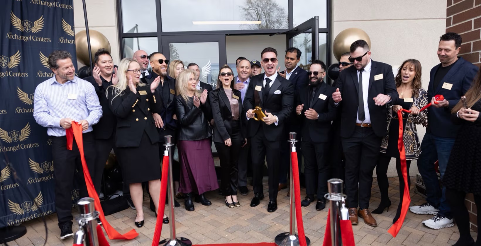 Ribbon-cutting moment at The Archangel Centers grand opening, Mike Sorrentino with team and supporters